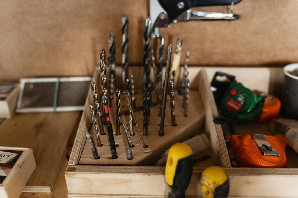 A detailed view of assorted drill bits and carpentry tools neatly stored in a wooden organizer.