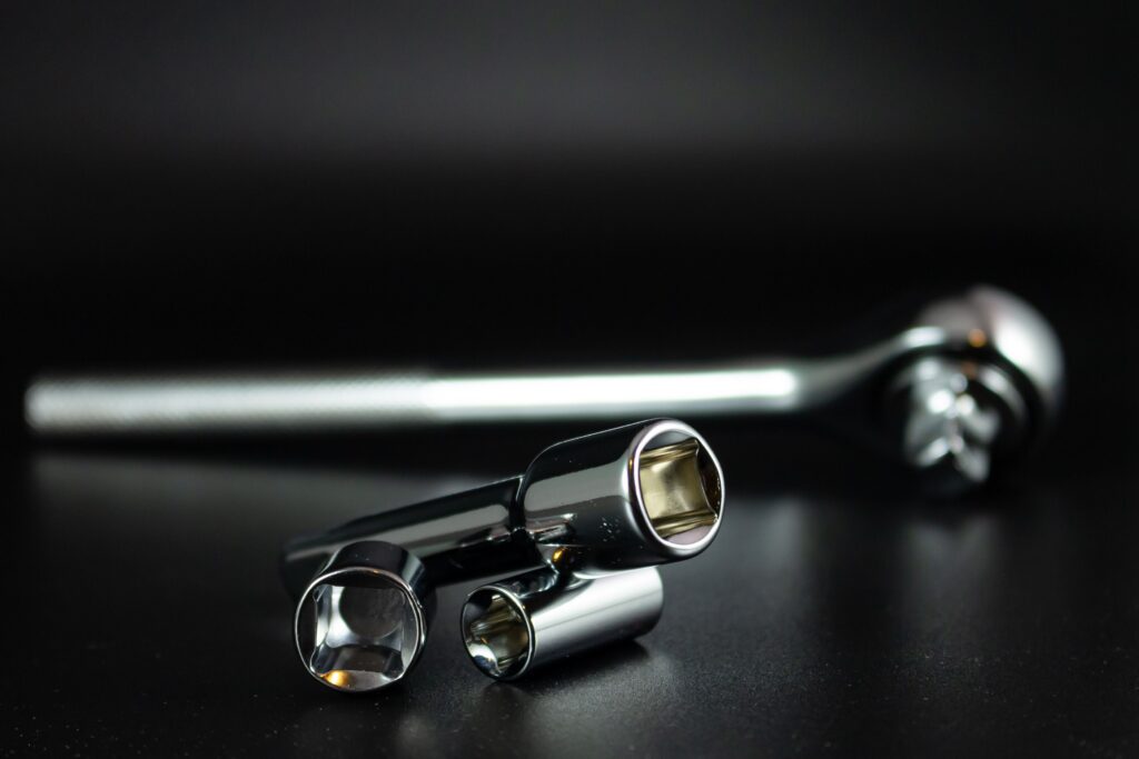 A detailed studio shot of a chrome socket wrench set with a black background, highlighting precision tools.